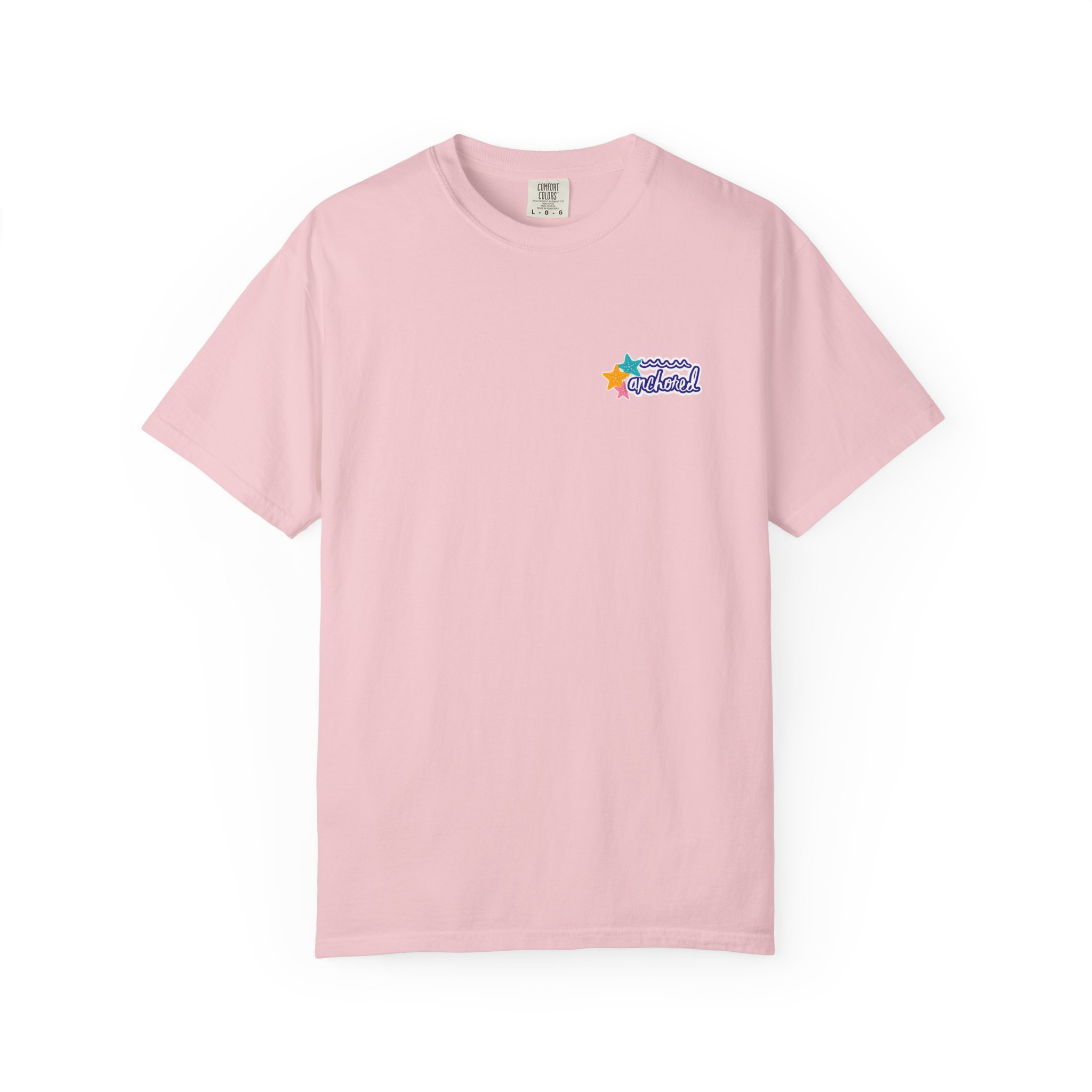 8266116549875442489_2048jpeg - Anchored Pink T-shirt laid flat with a small colorful star and wave graphic and the word 'anchored' on the chest area.